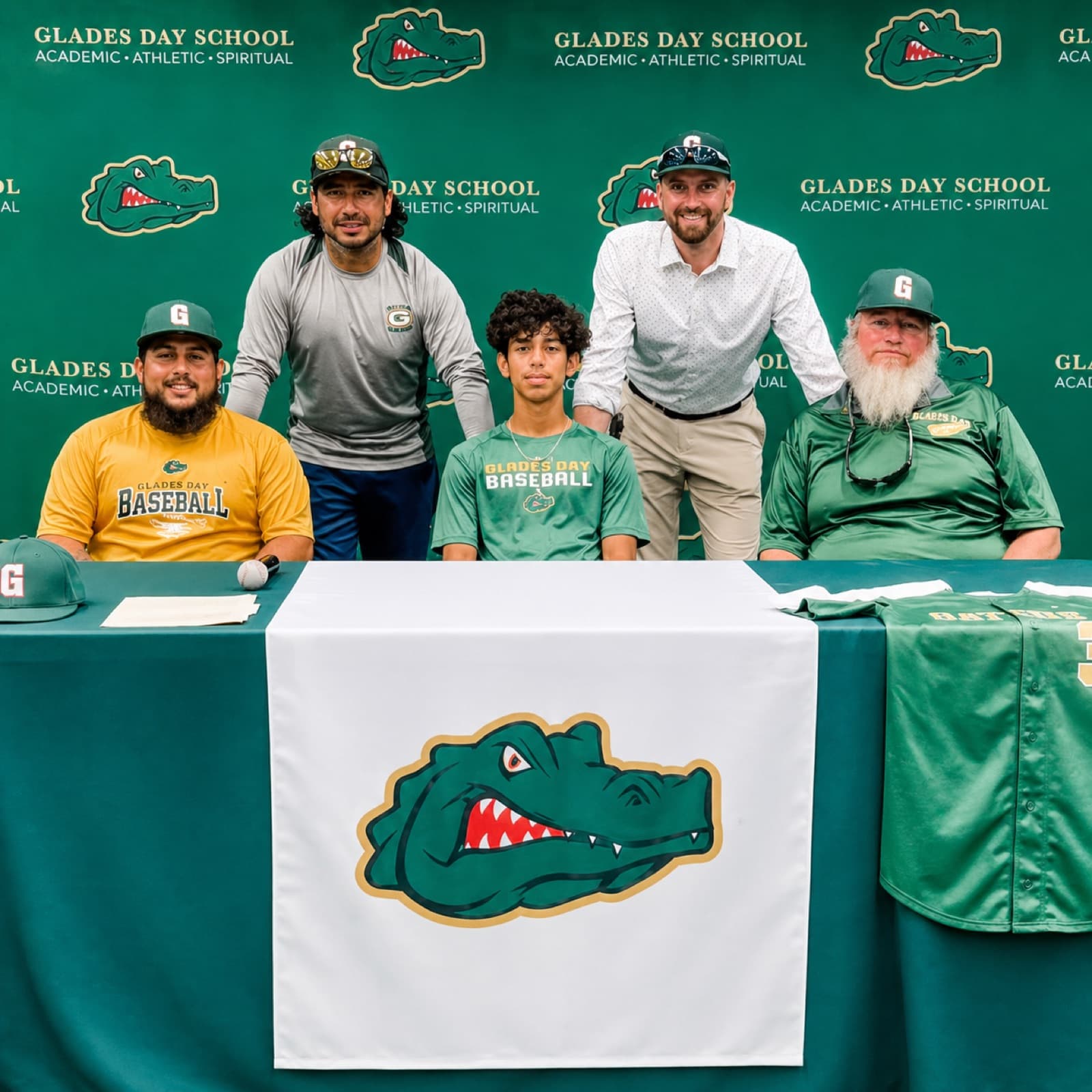 Rene Leon Jr. with a Glades Day School baseball player and family on signing day